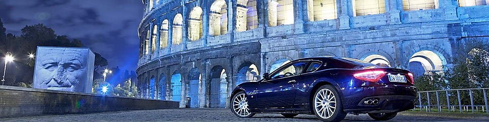 Car parked outside of the Colosseum in Rome at night