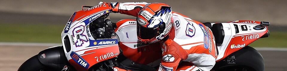 Motorcycle with rider racing around the corner of a track