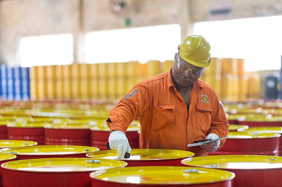 man assesses lubricant barrels