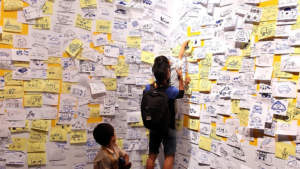 Visitors post 'ideas' on an interactive wall at the 'Experience' during day four of the Shell Eco-marathon 